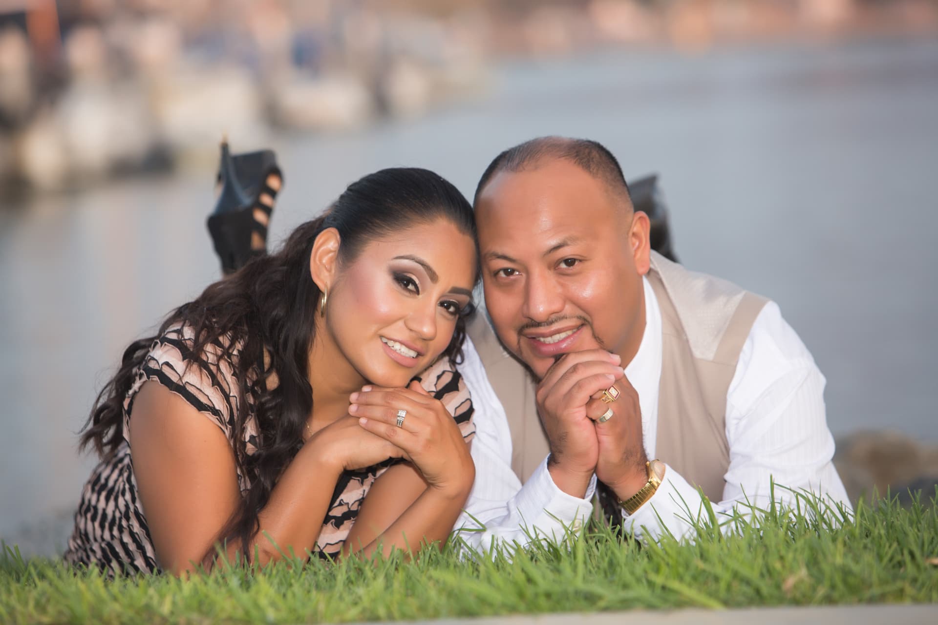 Engaged couple smiling together beside the marina