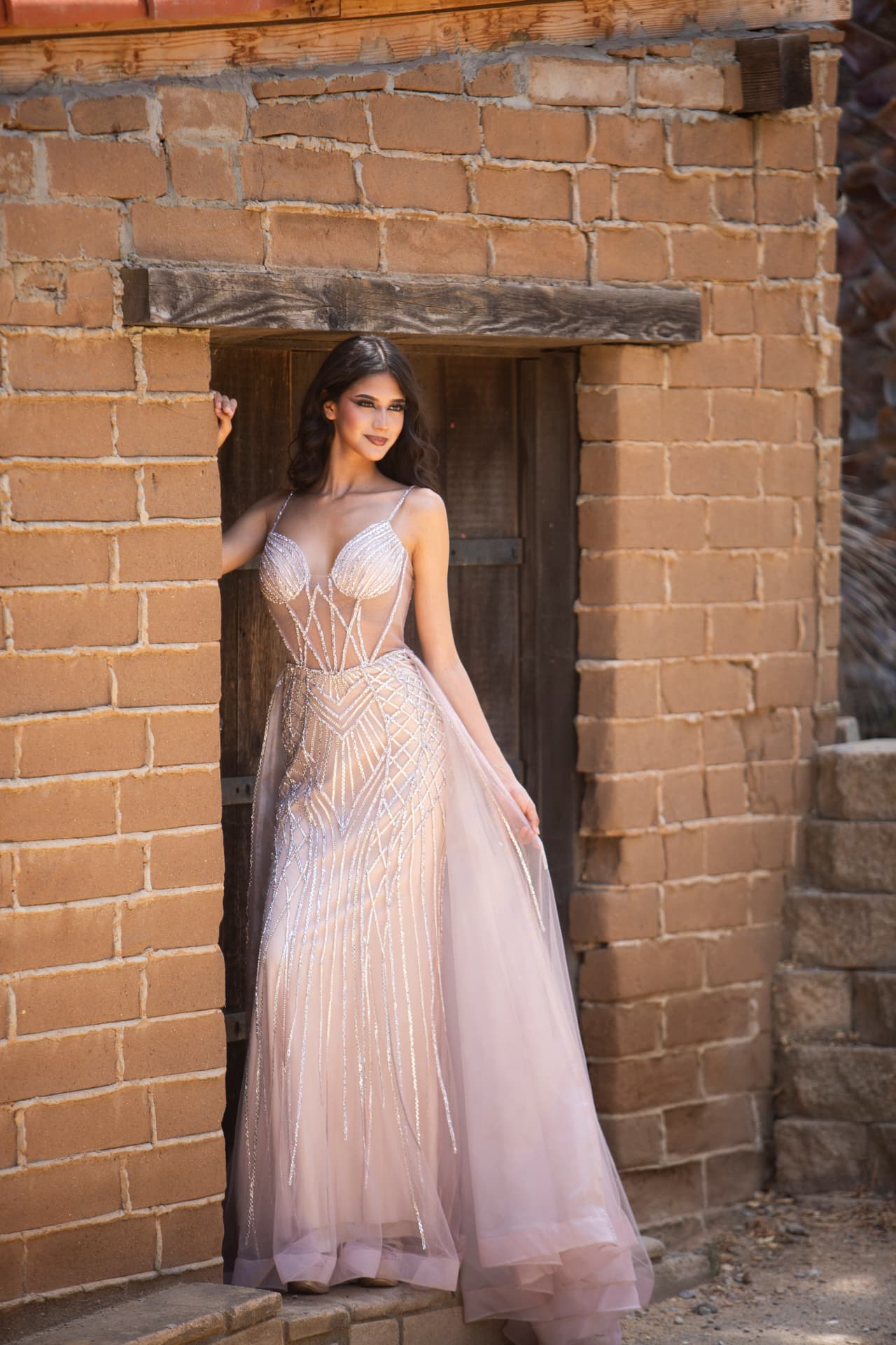 Full-length fashion portrait of a model framed by an adobe doorway
