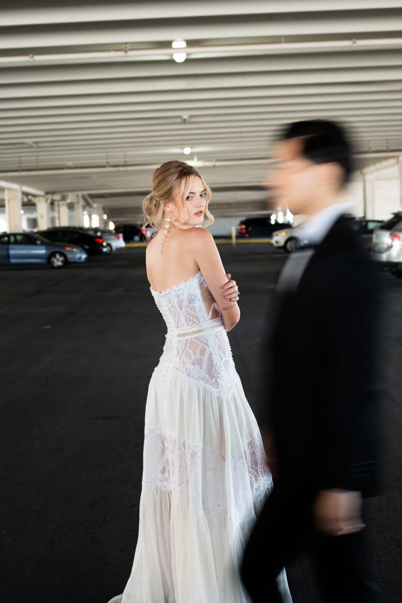 Bride looking over her shoulder as the groom passes in a creative motion portrait