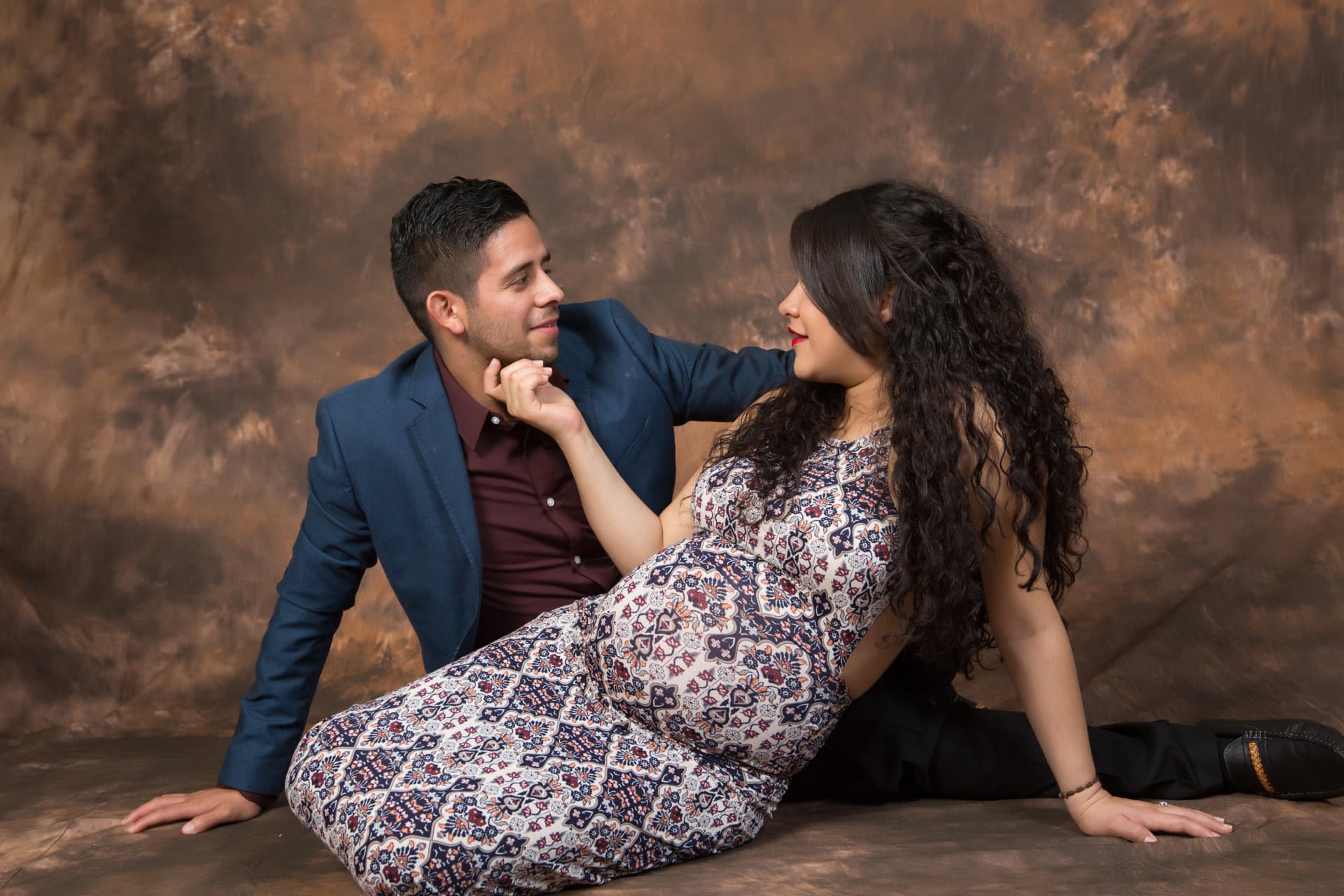 Expectant couple seated together and looking at one another