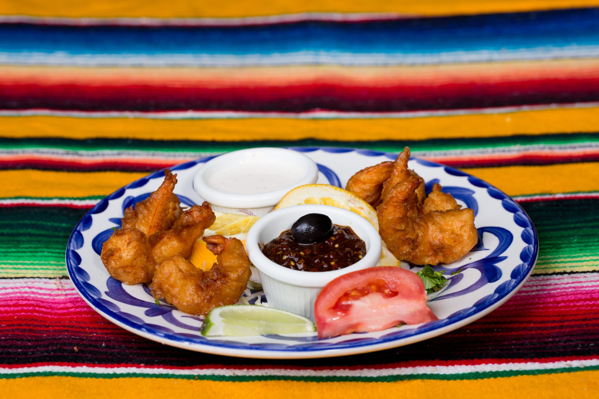 Golden fried shrimp served with two dipping sauces, tomato, orange, and lime