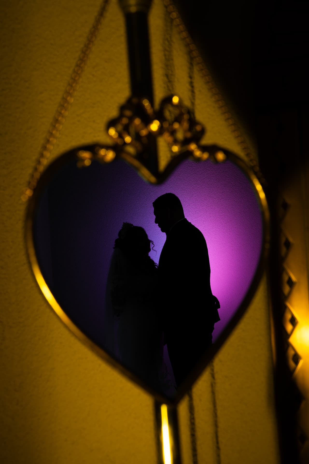 Silhouette of a newlywed couple framed inside a glowing heart