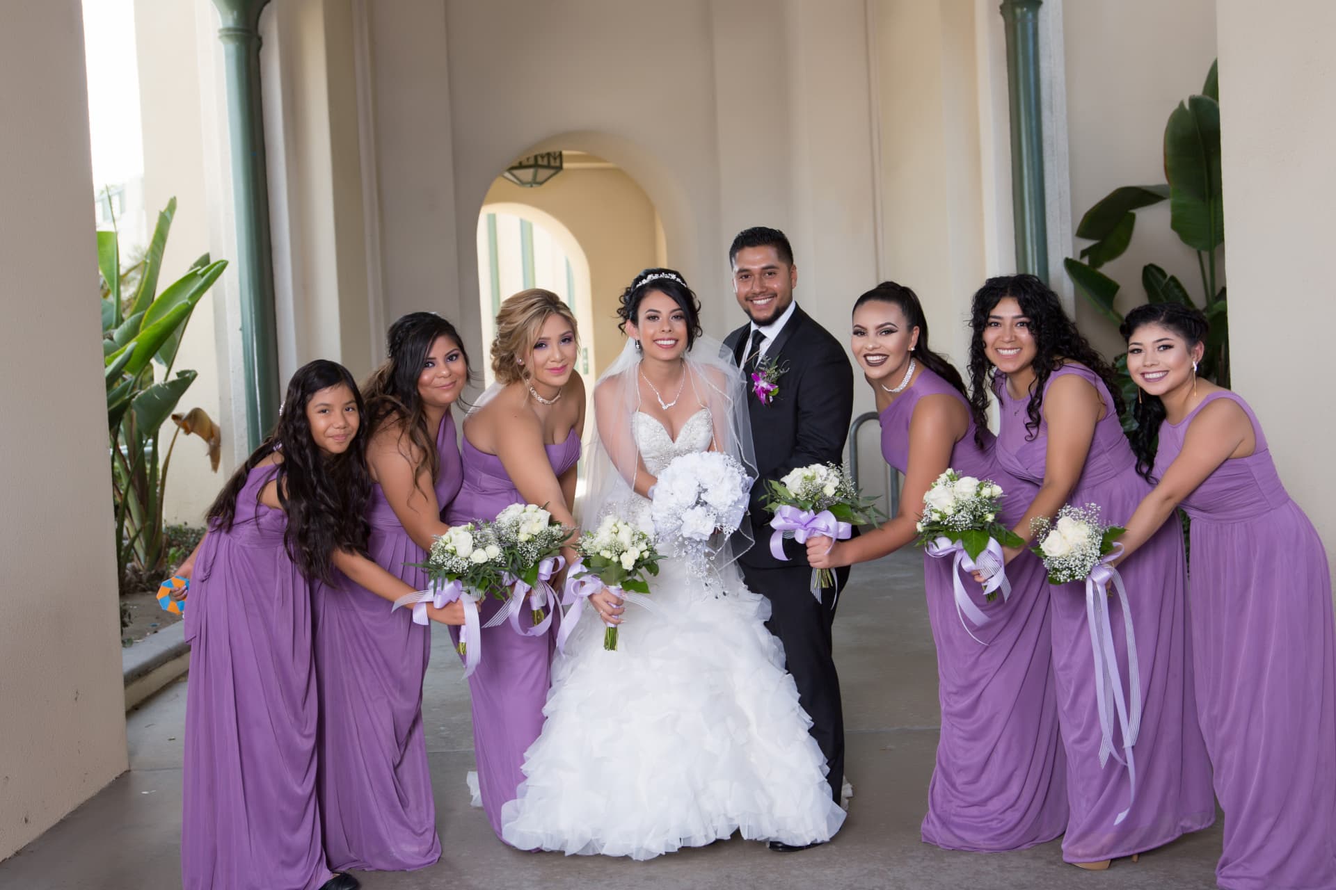 Bride and groom surrounded by bridesmaids in lavender dresses