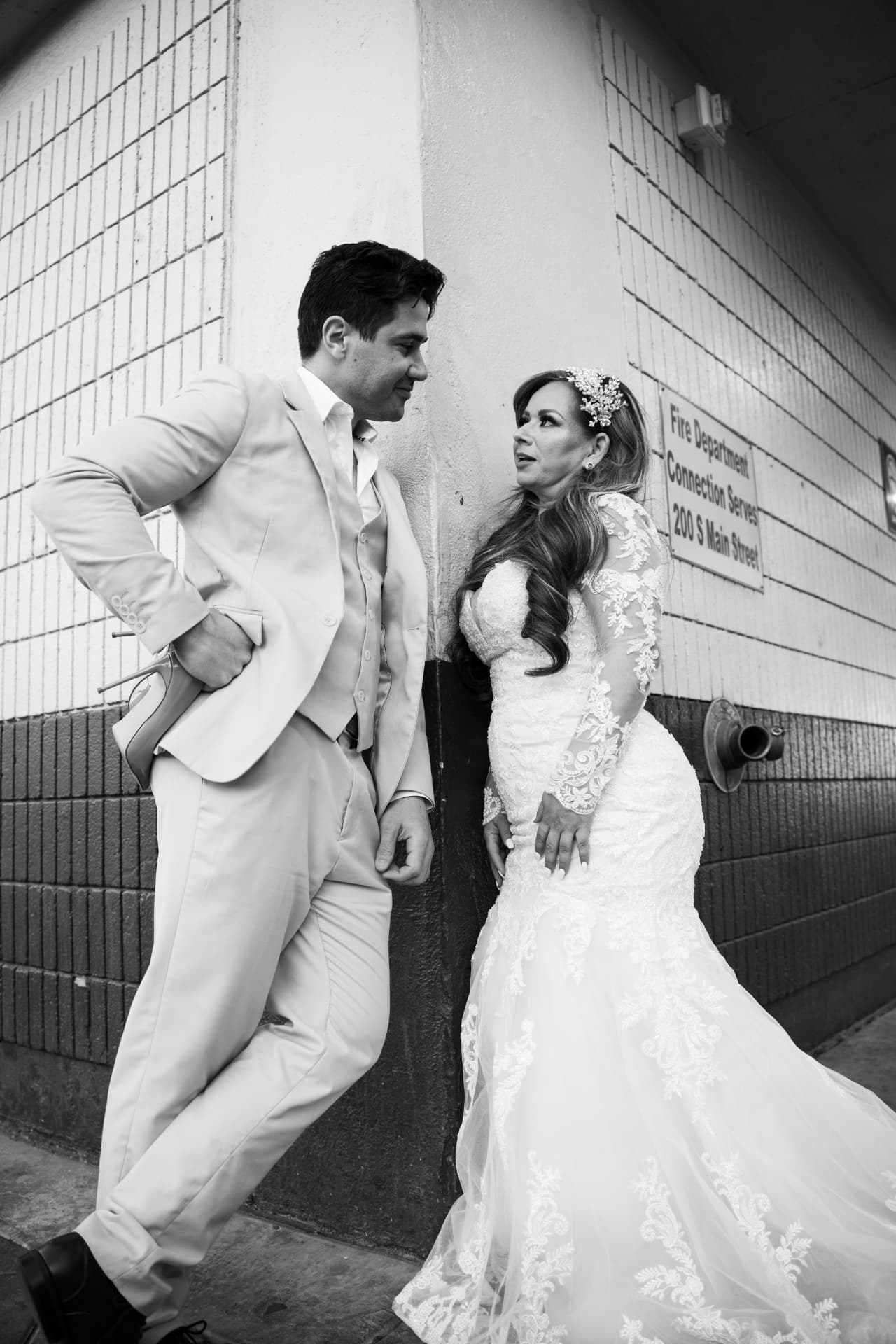 Bride and groom sharing a candid moment in a black-and-white city portrait