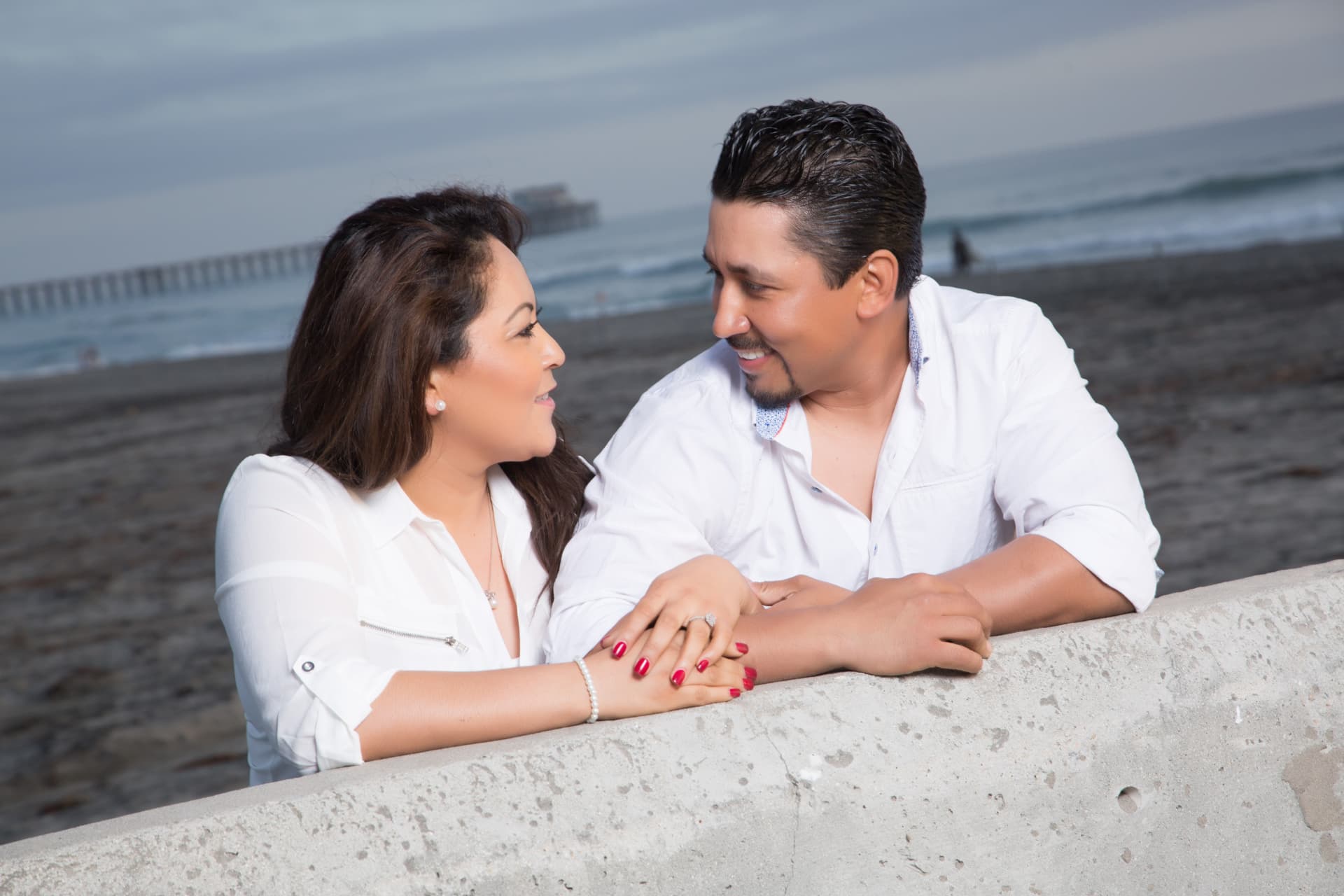 Engaged couple exchanging a smile beside the beach